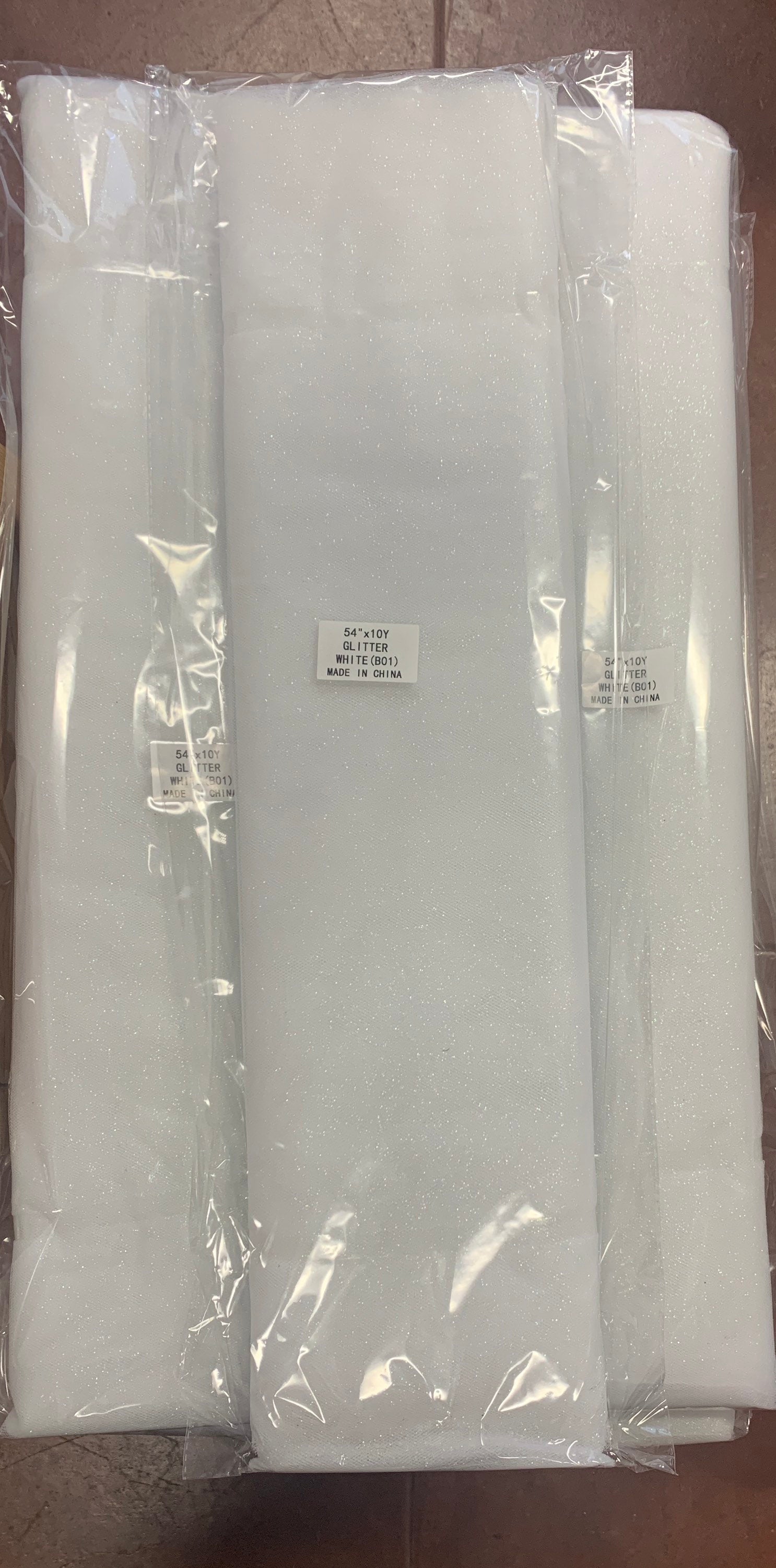 White Glitter Tulle 54" double fold, color White with unicorn glitter 10 yards per pack.