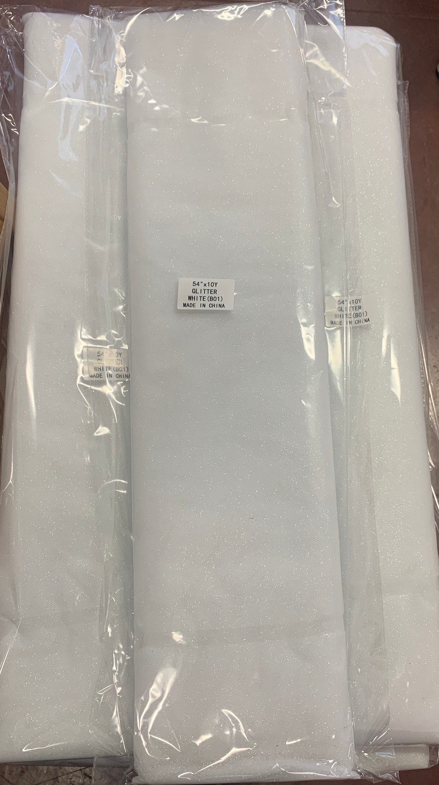 White Glitter Tulle 54" double fold, color White with unicorn glitter 10 yards per pack.