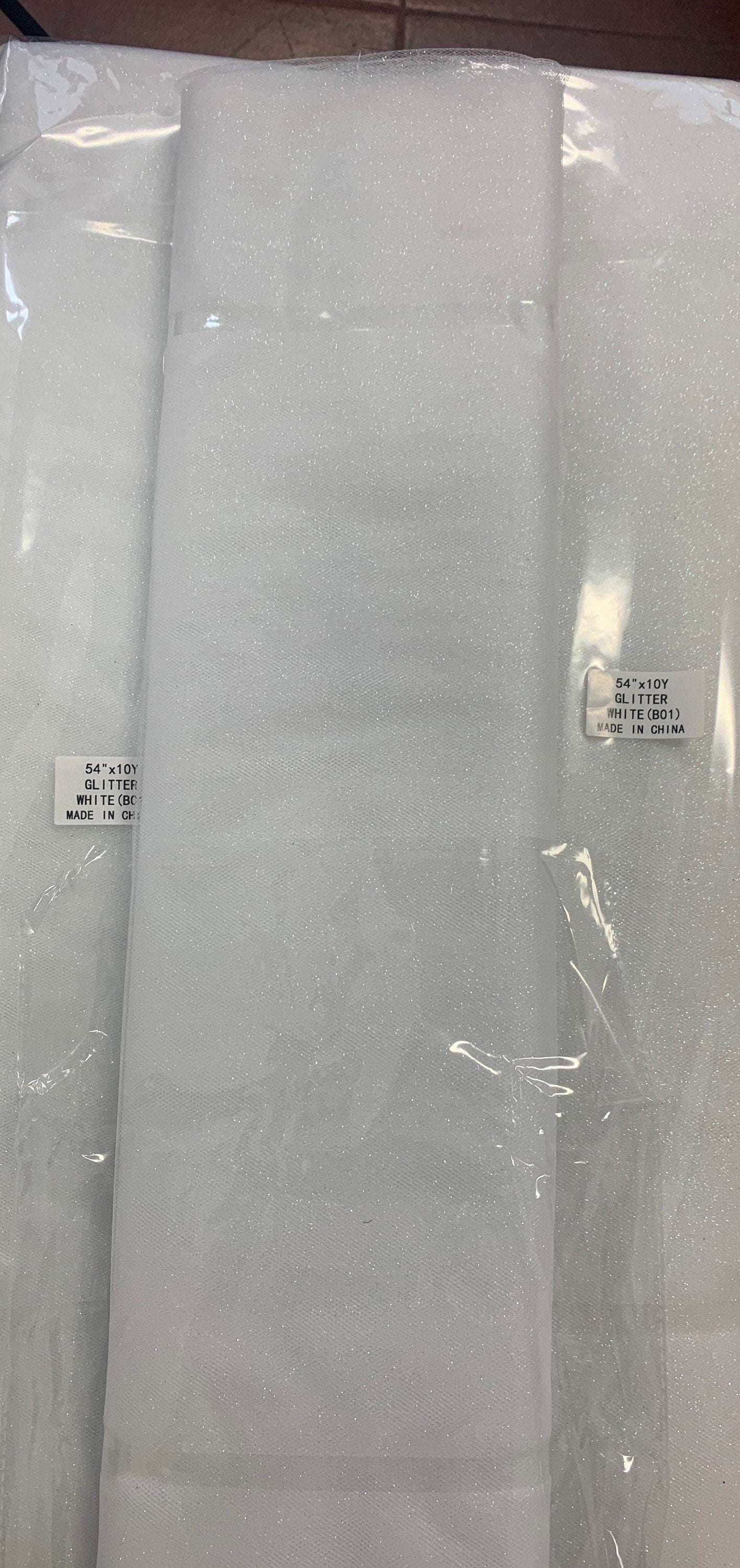 White Glitter Tulle 54" double fold, color White with unicorn glitter 10 yards per pack.