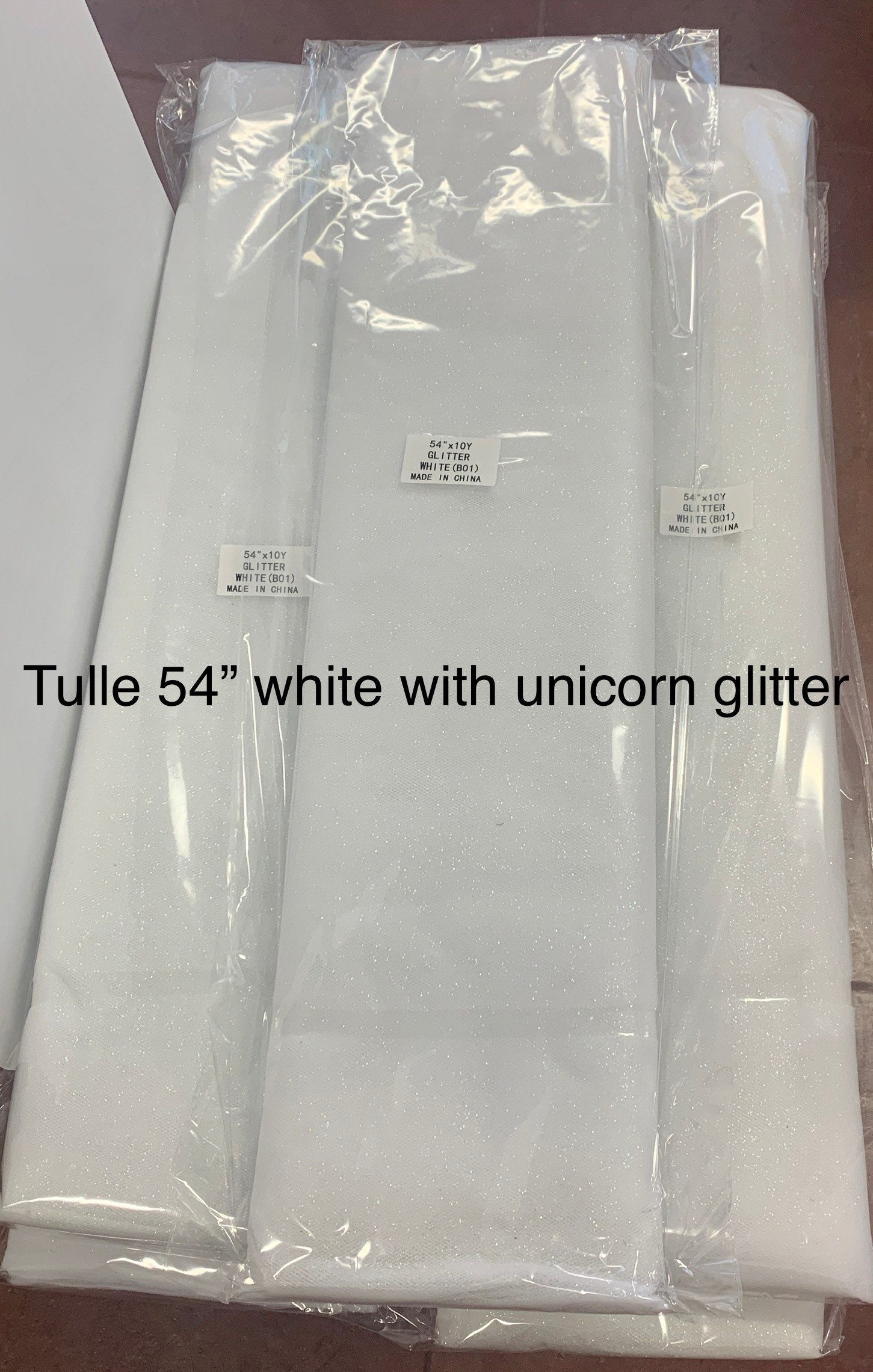 White Glitter Tulle 54" double fold, color White with unicorn glitter 10 yards per pack.