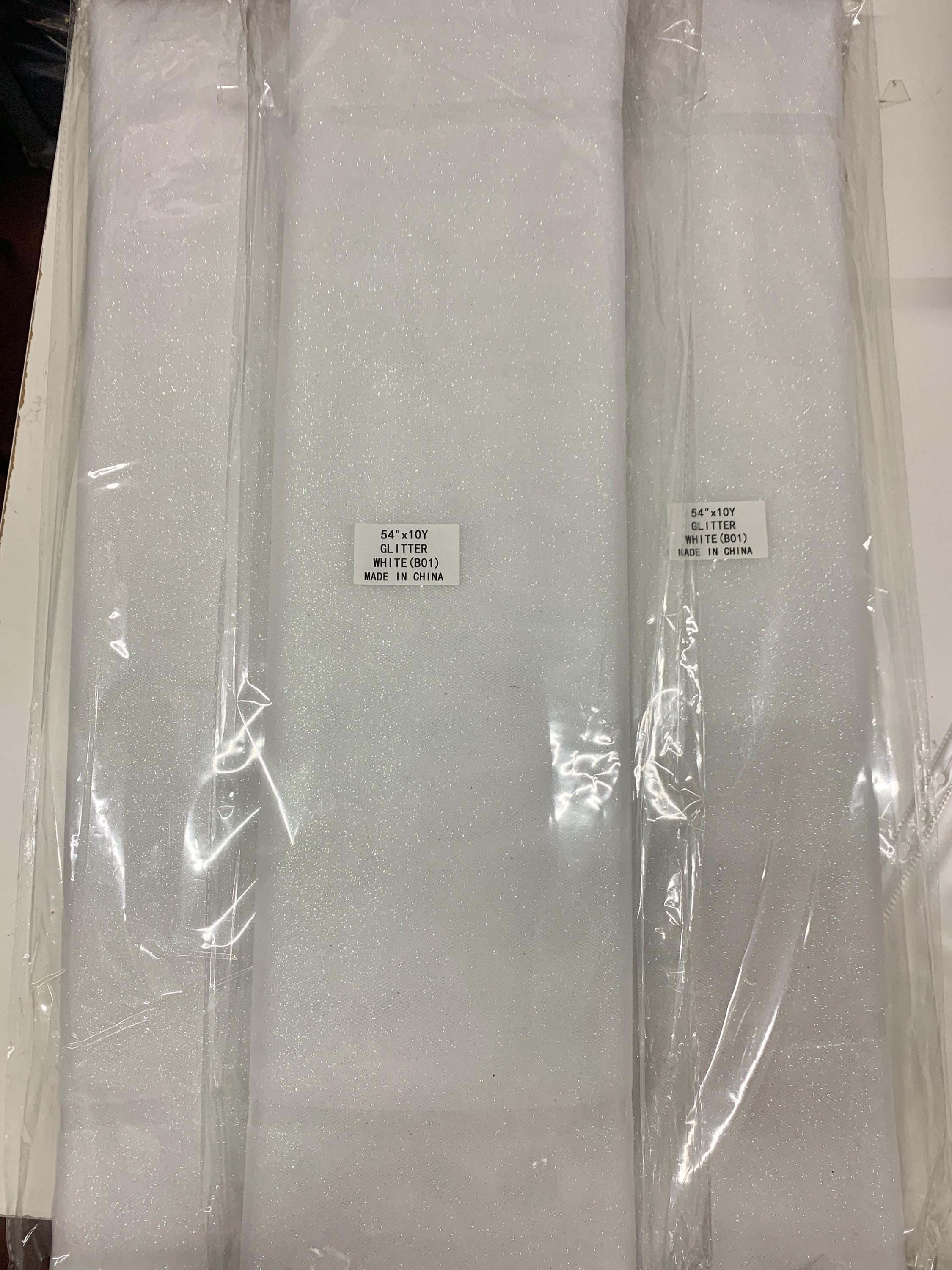 White Gliter Tulle 54" double fold white with unicorn gliter 10 yards per pack.