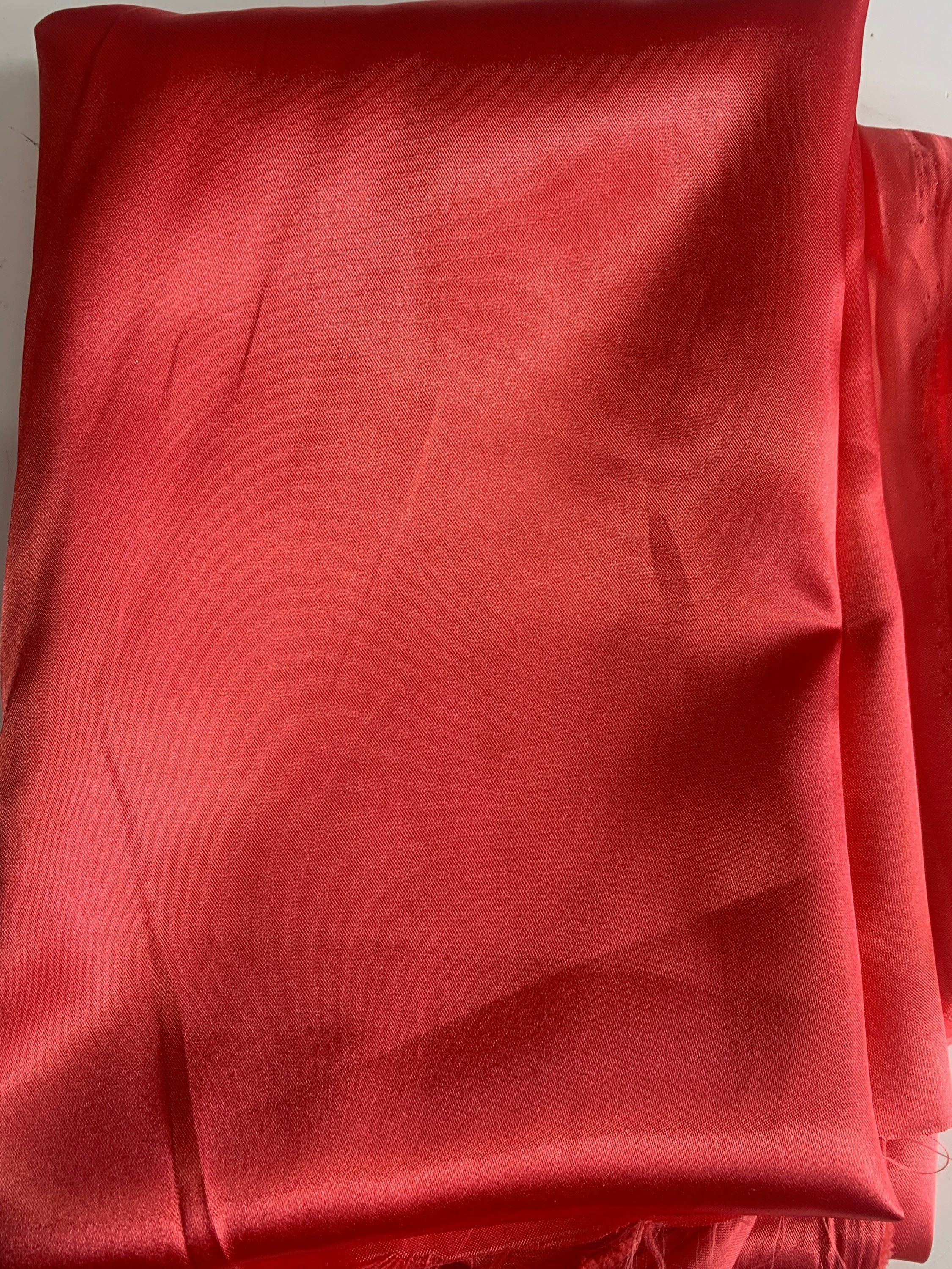 Red charmeuse satin 100% polyester color is dark coral. Lustrous , smooth fabric, shiny on front and matte in back