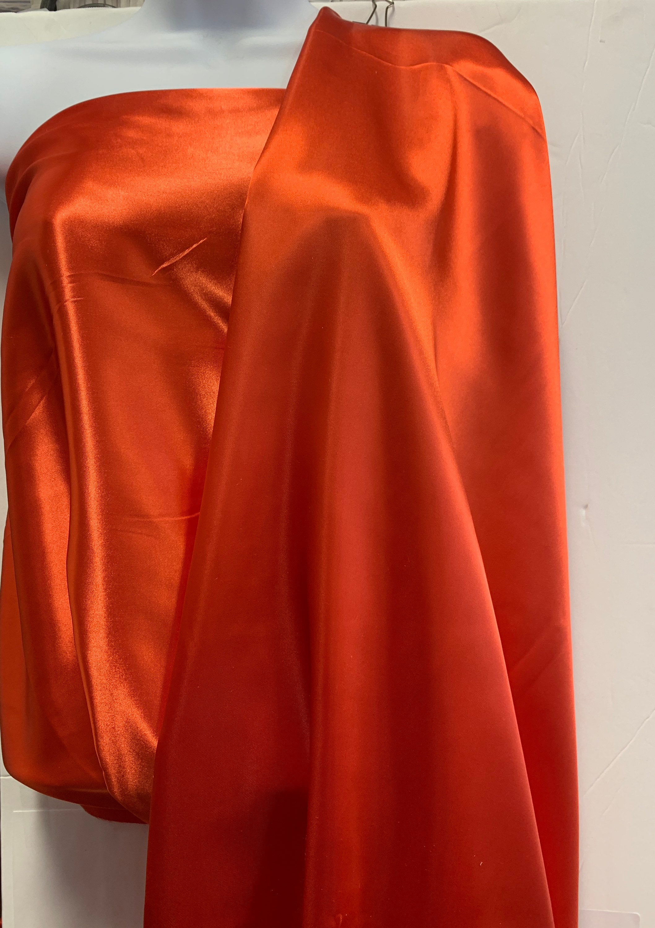 Soft silky satin fabric, width 58/60 inches 100% polyester color Coral known as Charmeuse satin fabric suitable for lingerie and apparel.