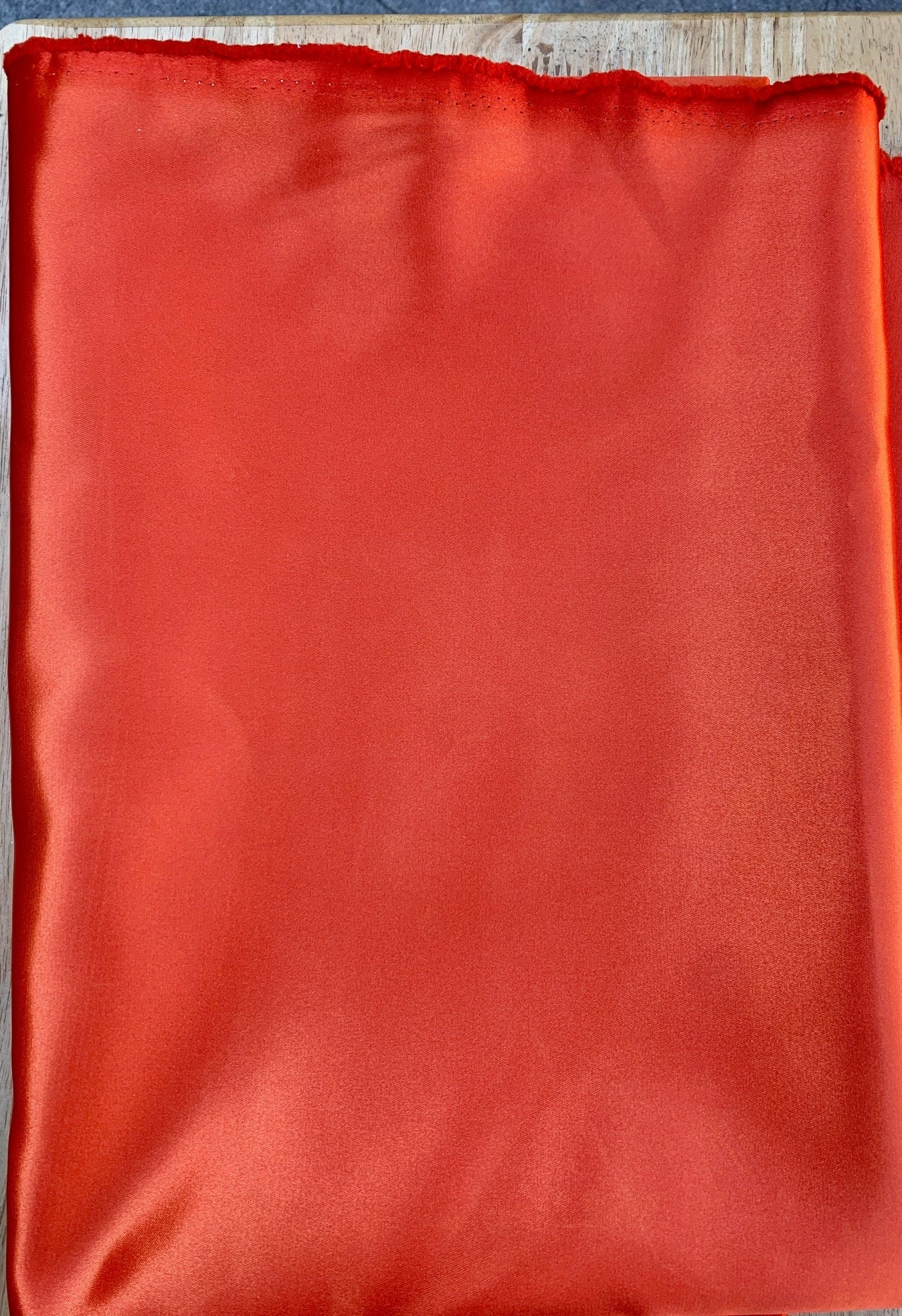 Orange color shiny Satin fabric width 59 inches. sell by yard.