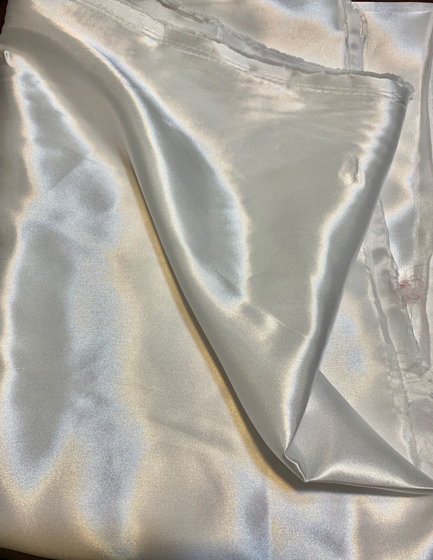 Charmeuse satin sell by yard color white width 58 inches. Soft satin fabric 100% polyester Lustrous , smooth and shiny fabric,