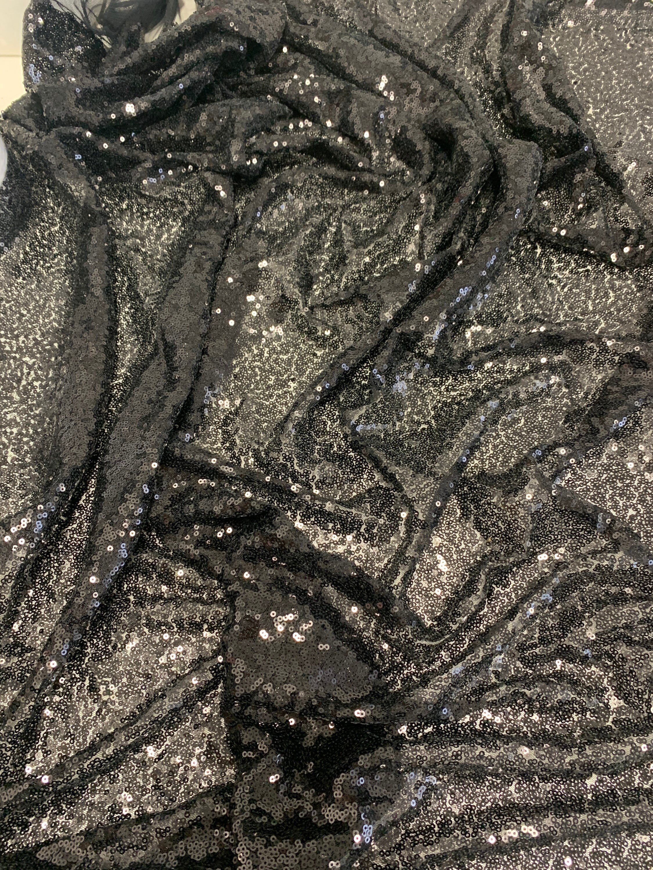 Black Sequins Mesh fabric width 56/57 inches sequins area 48 inches fabric has salvage mesh fabric on both side.
