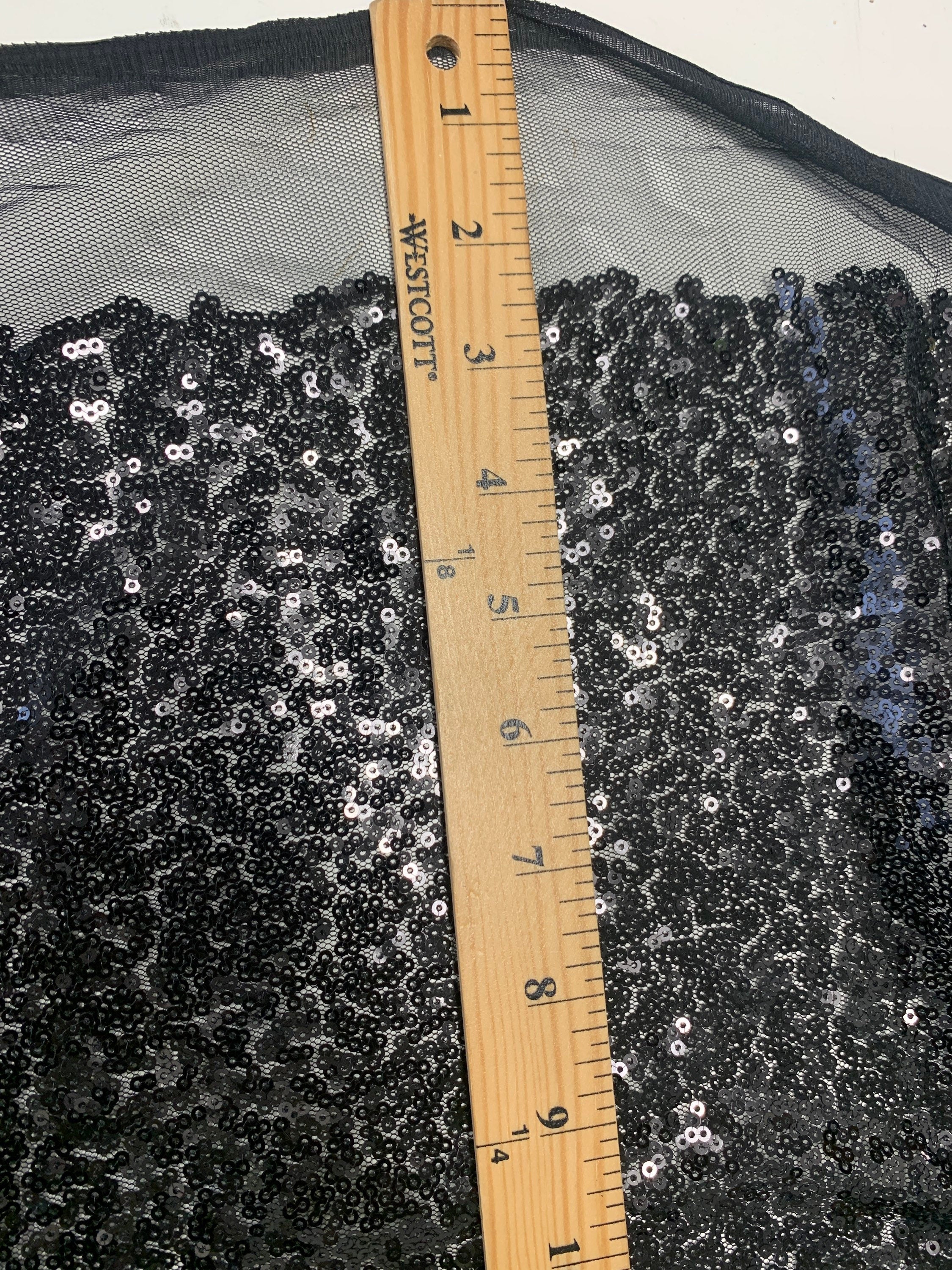Black Sequins Mesh fabric width 56/57 inches sequins area 48 inches fabric has salvage mesh fabric on both side.