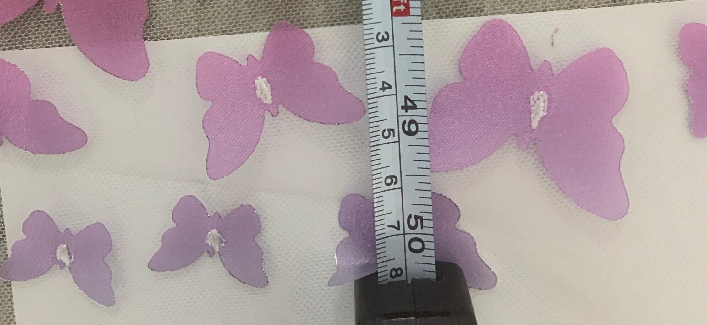 lace Butterfly on mesh design fabric. color rainbow. 60 inch width,fabric has 5 inch plain salvage on each side. butterfly are is 50 inches.