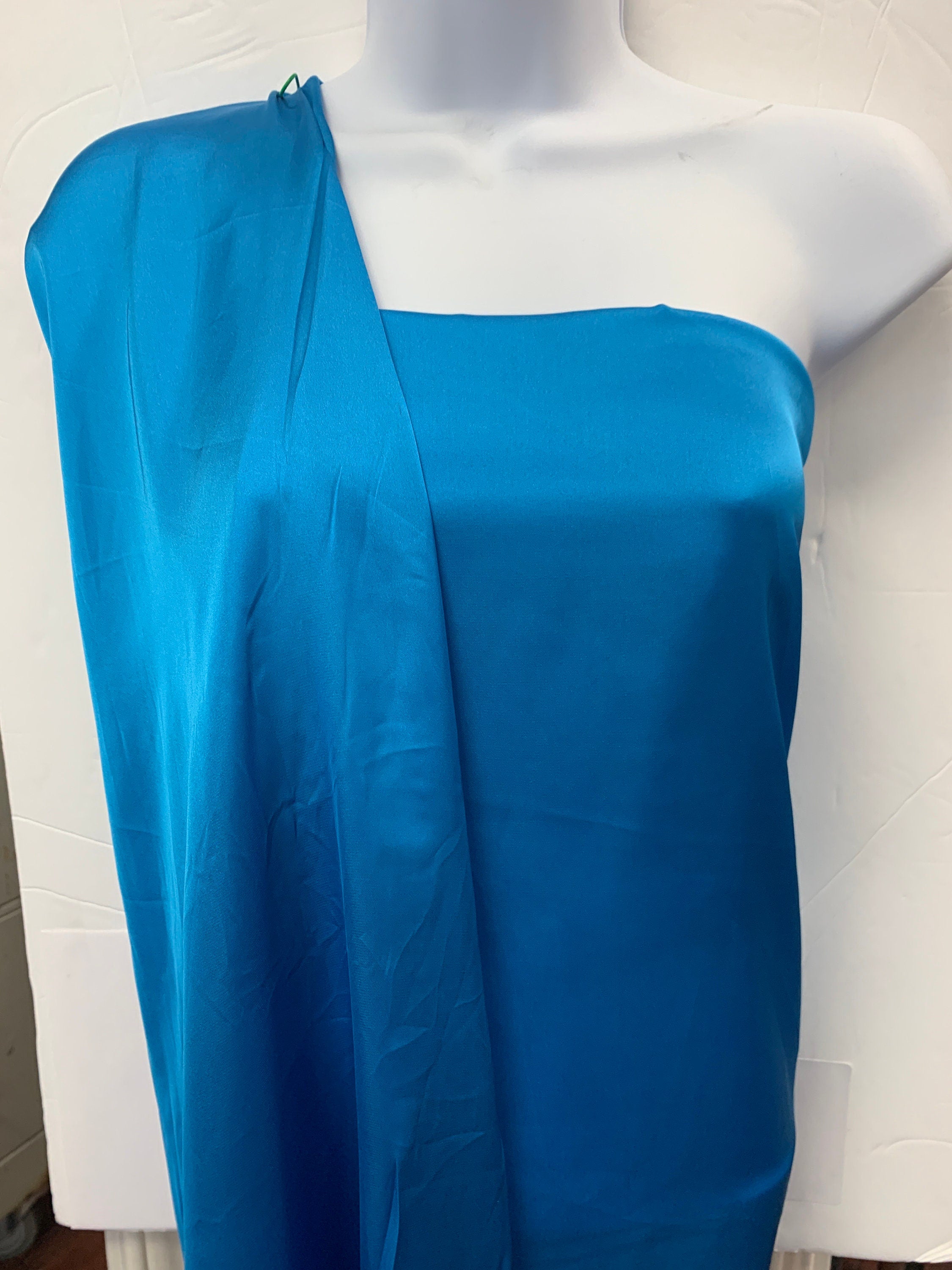 Silky dull satin fabric sell by yard 58/60" 100% polyester. Turquoise colorsmooth texture. Perfect for stylish tops and blouses.