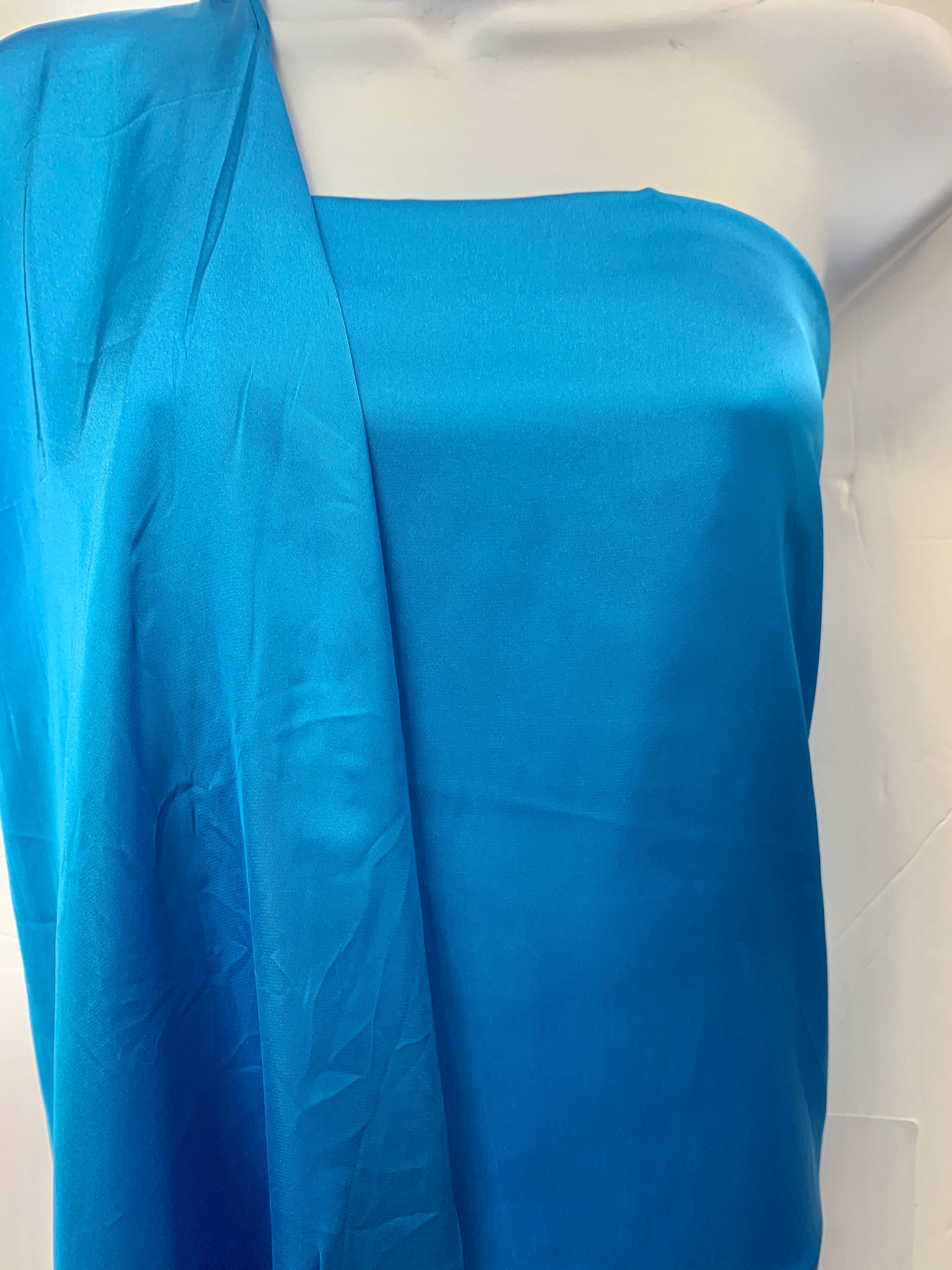 Silky dull satin fabric sell by yard 58/60" 100% polyester. Turquoise colorsmooth texture. Perfect for stylish tops and blouses.
