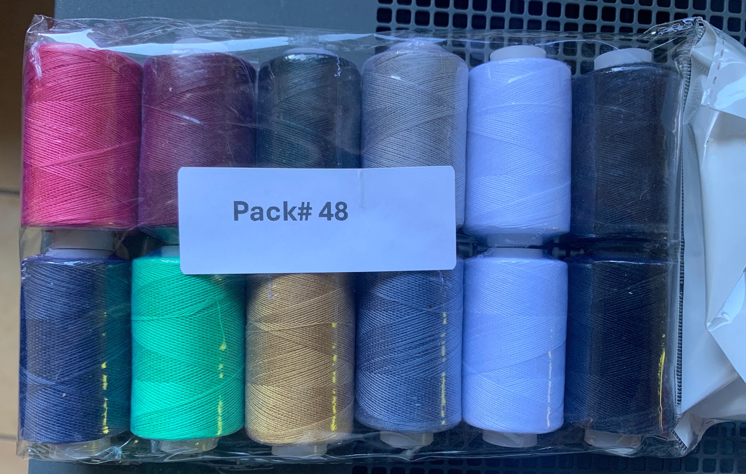 Sewing threads 12 assorted colors per package, each package assortment is different from each other, all packages has 2 black and 2 white.