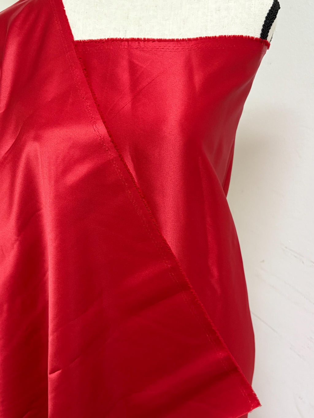 A 2 yards cut fantasy satin width 60", 100% polyester color red suitable for dress. sell by 2 yards increment continuous. Known as L'Amour