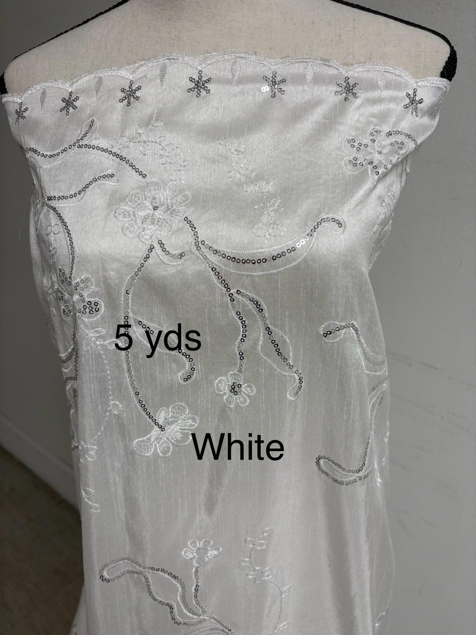 A 5 yards White satin Shantung Fabric width 58 inches polyester. Double scalloped sequins embroidery with slubbed texture.