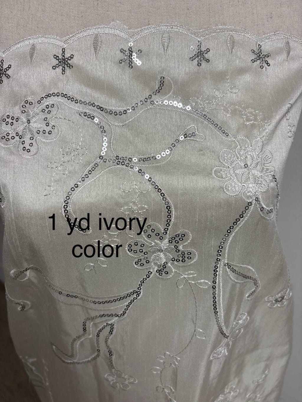 A 3 yards Ivory satin Shantung Fabric width 58 inches polyester. Double scalloped sequins embroidery with slubbed texture.