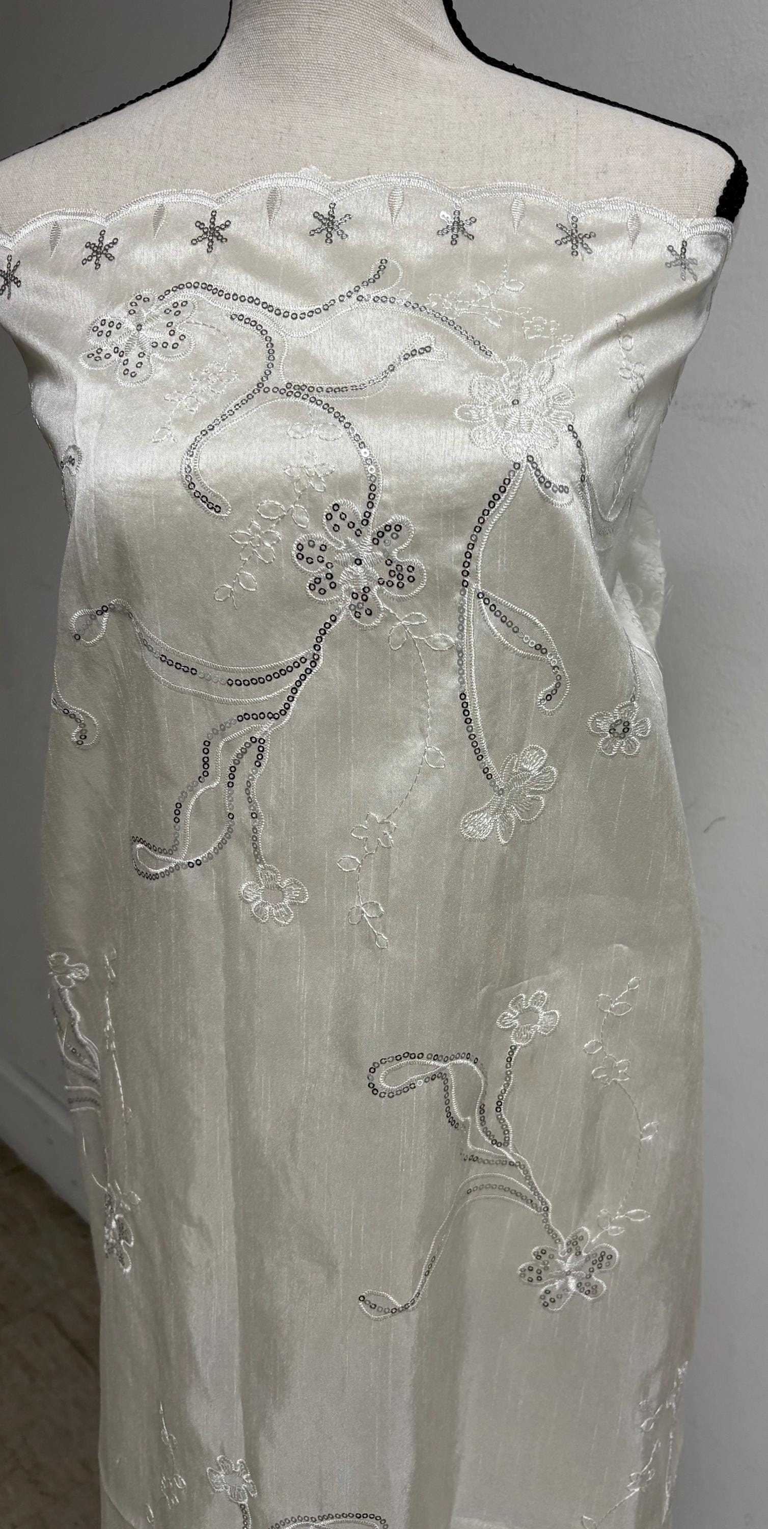 A 3 yards Ivory satin Shantung Fabric width 58 inches polyester. Double scalloped sequins embroidery with slubbed texture.