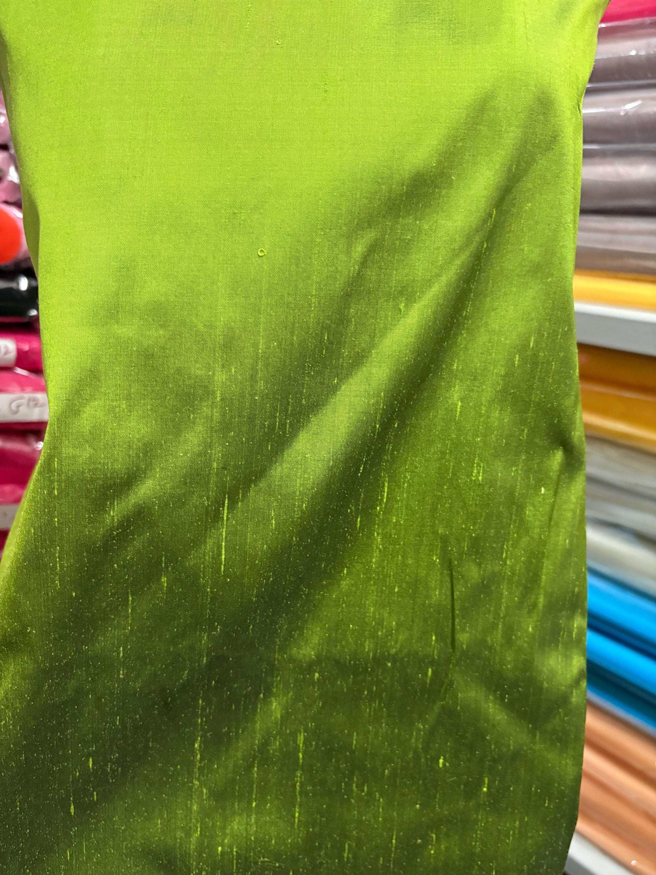 100% silk Dupioni Taffeta width 54" color is two tone Olive with black tone. Machine made, fabric has slubs. Item # 3. free sample.