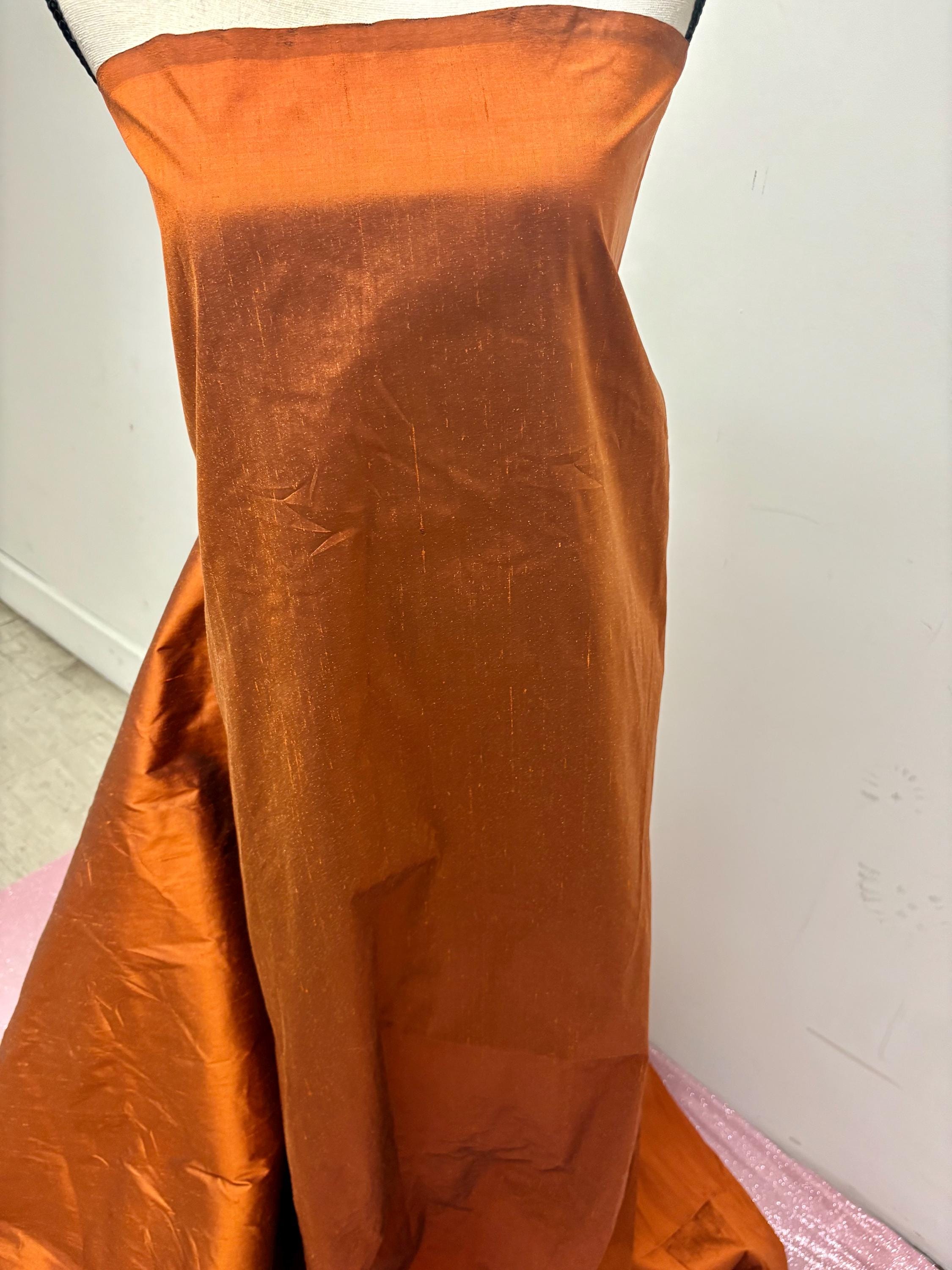 100% silk Dupioni Taffeta width 54" color is Rust with black warp. Machine made, fabric has slubs. Item # 8. free sample. Nas2224-B