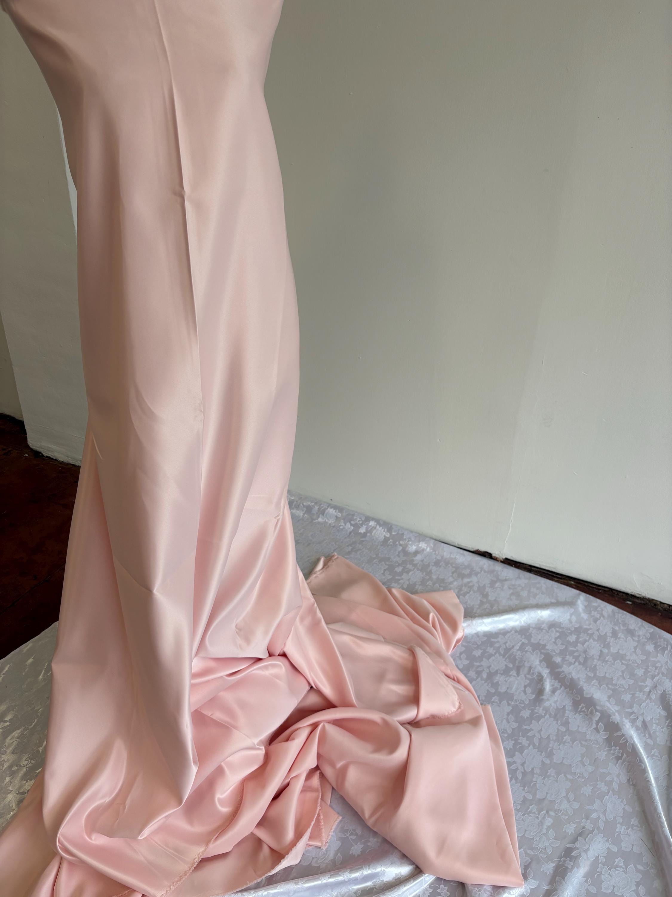 Light pink dull satin fabric, 58/60” wide, made of polyester – an excellent choice for gowns.