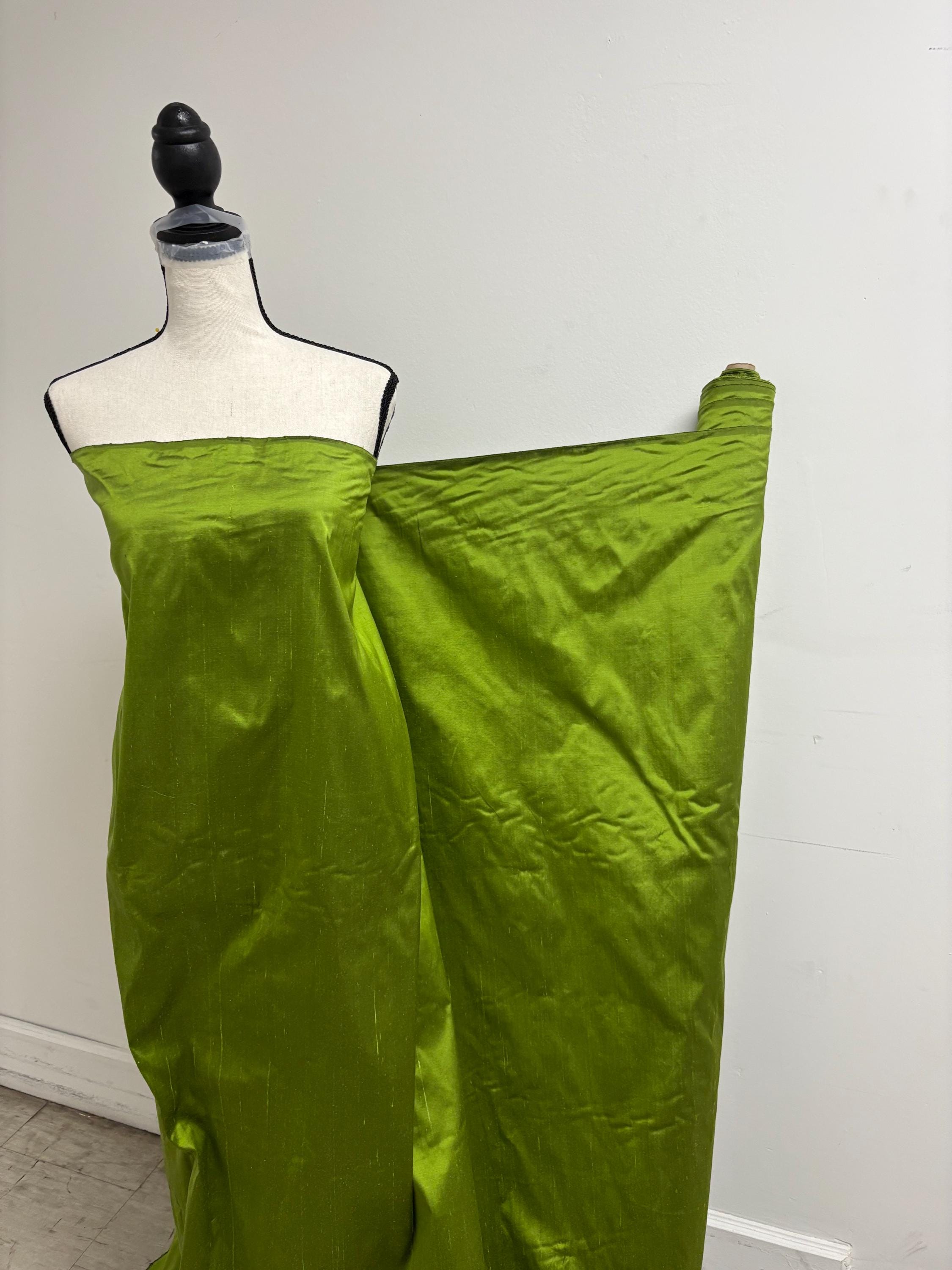 100% silk Dupioni Taffeta width 54" color is Lime with black warp. Machine made, fabric has slubs. free sample. Nas2244