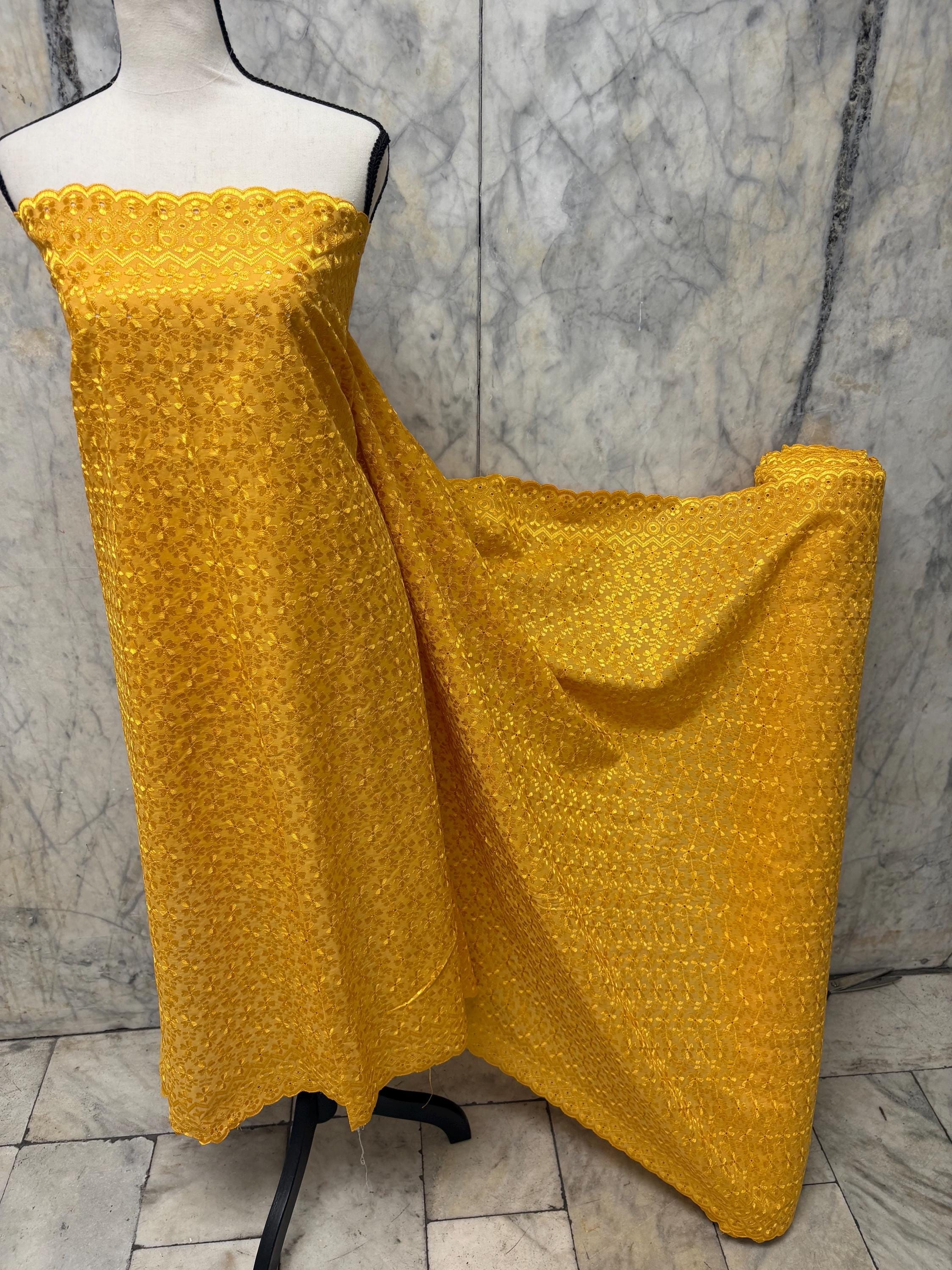 Eyelet fabric made of poly-cotton with all-over embroidery and double scalloped edges for a delicate finish. color Gold design # 2