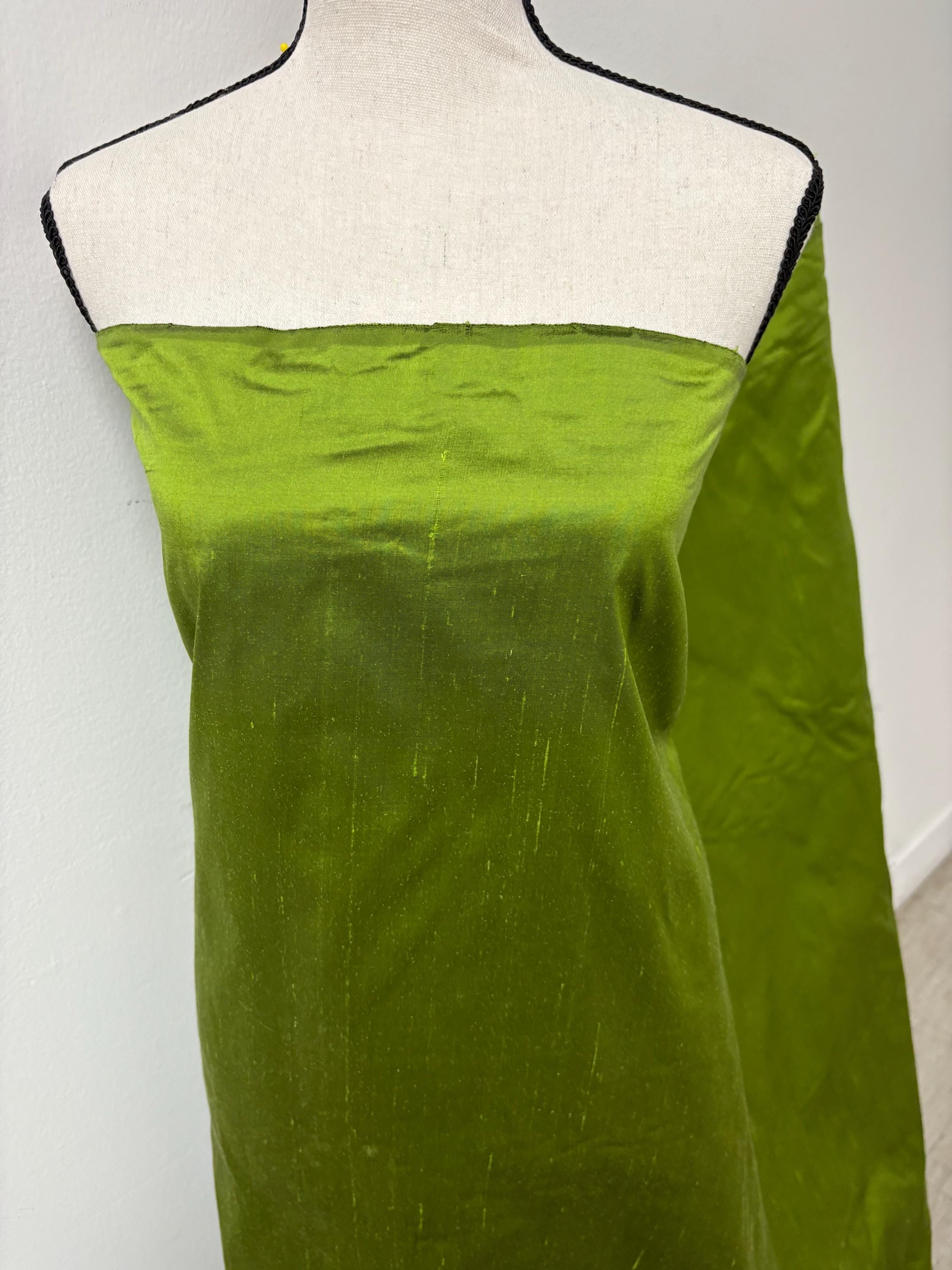 100% silk Dupioni Taffeta width 54" color is Lime with black warp. Machine made, fabric has slubs. free sample. Nas2244