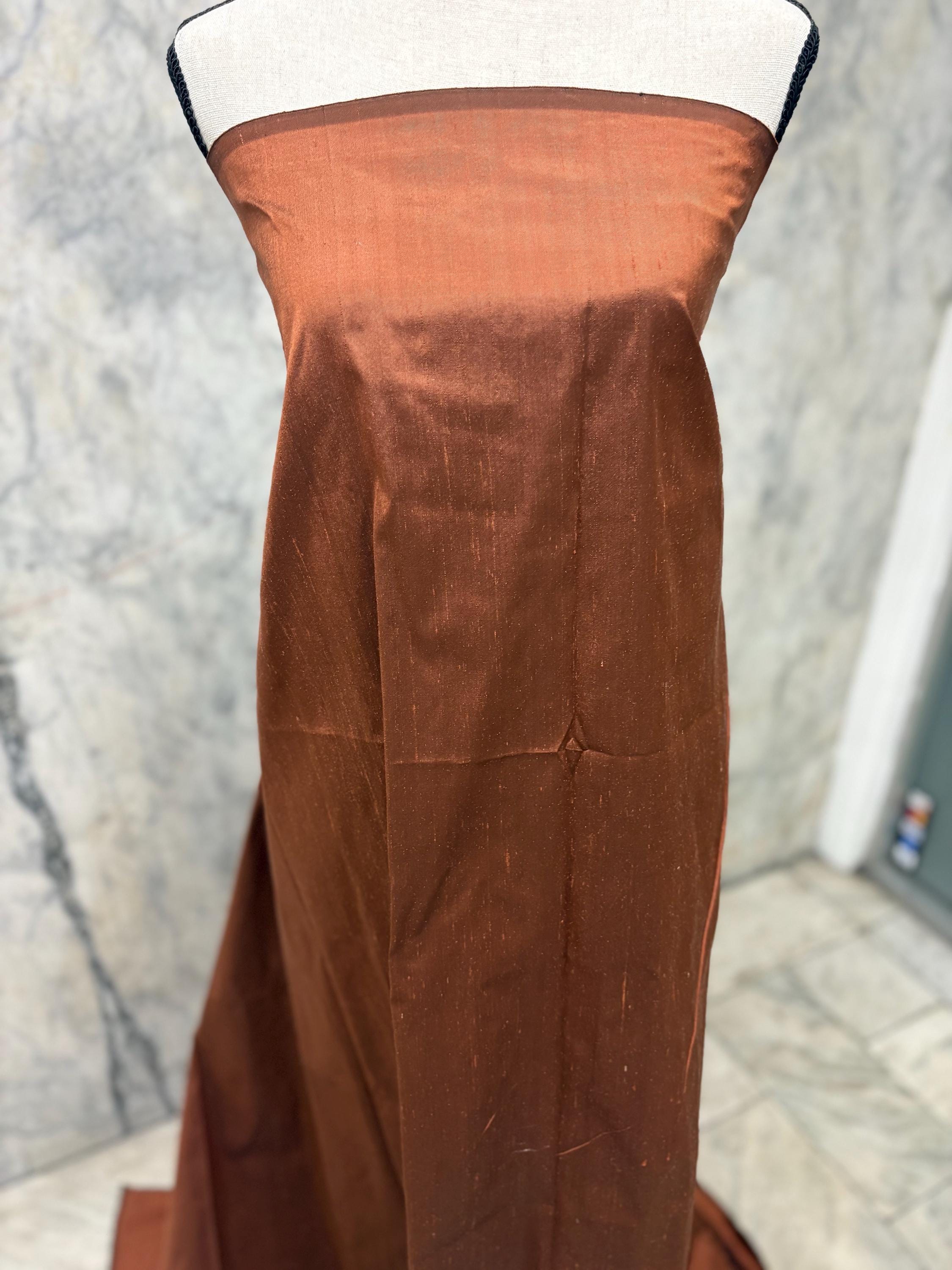 100% silk Dupioni Taffeta width 54" color is Rust with black warp. Machine made, fabric has slubs. free sample. Nas2224-B (dark shade)