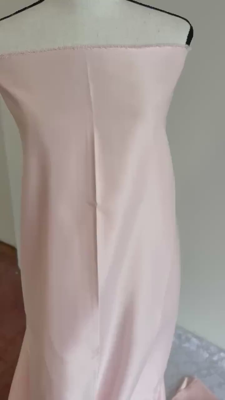 Light pink dull satin fabric, 58/60” wide, made of polyester – an excellent choice for gowns.